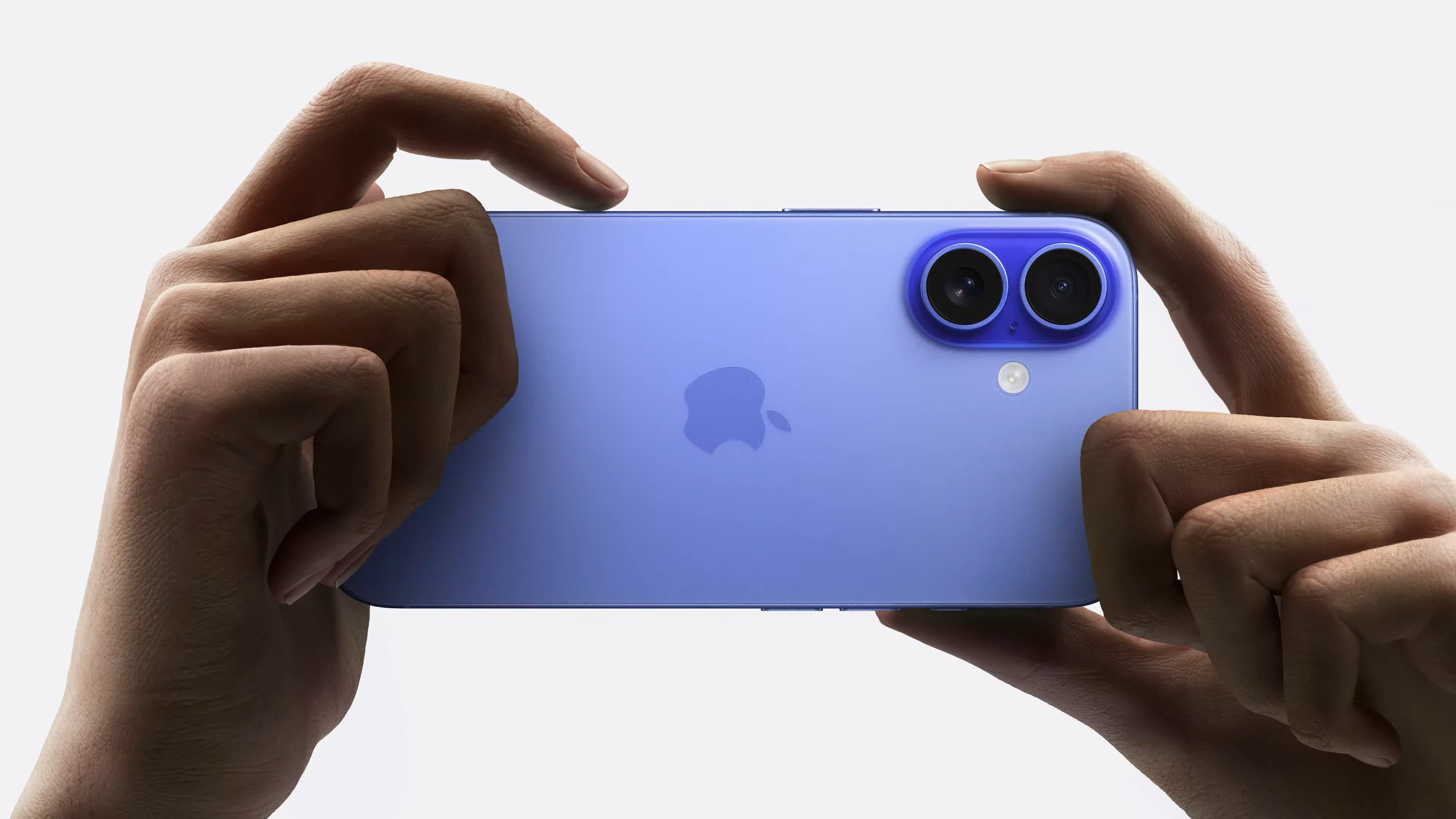 A person holding the iPhone 16 while using its new Camera Control button.